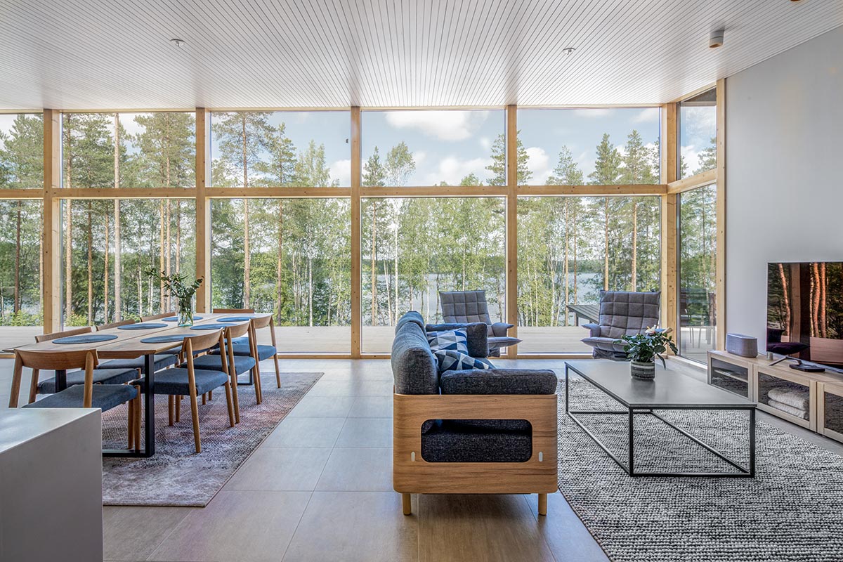 Pluspuu UK interior design — open-plan living with timber beams and glass wall